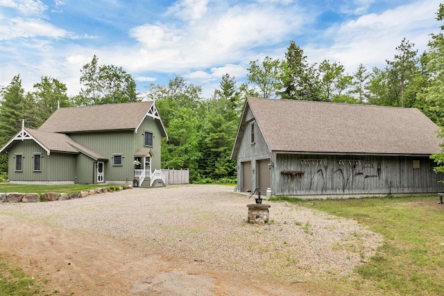 185 Huntress Bridge Rd, Effingham, NH 03882 - view of side of home with an outbuilding, a shingled roof, gravel driveway, and a garage