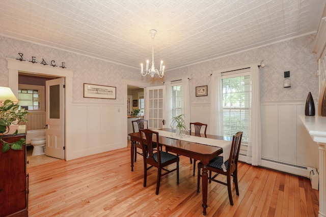 42 Lyndon St, Concord, NH 03301 - dining area with light wood-style flooring, a chandelier, ornamental molding, wainscoting, and baseboard heating