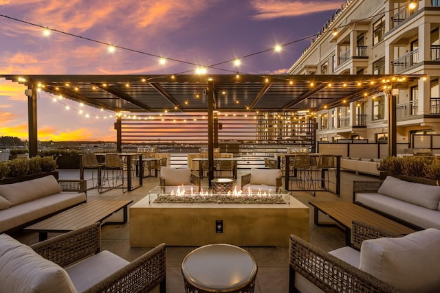 18 Artisan Dr Unit 416, Salem, NH 03079 - patio terrace at dusk with an outdoor living space with a fire pit, a pergola, and a patio area