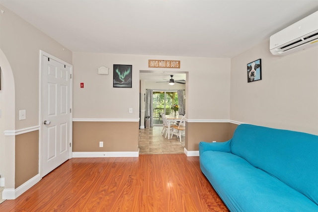 70 Riverside Dr, Allenstown, NH 03275 - living area with a wall mounted AC, wood finished floors, and a ceiling fan