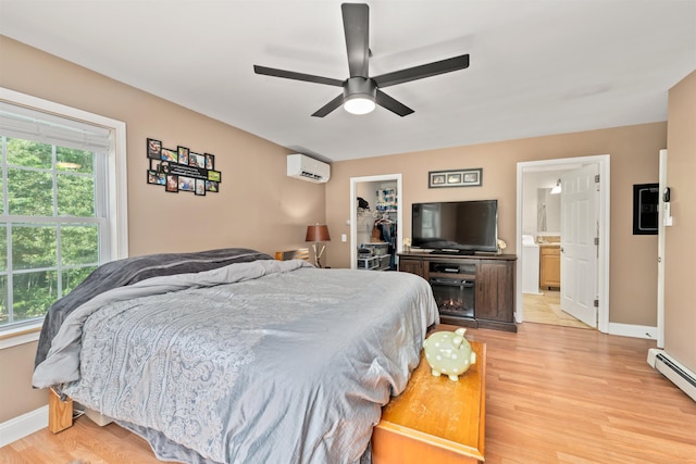 70 Riverside Dr, Allenstown, NH 03275 - bedroom featuring a wall mounted AC, a baseboard radiator, light wood-style floors, a walk in closet, and a closet