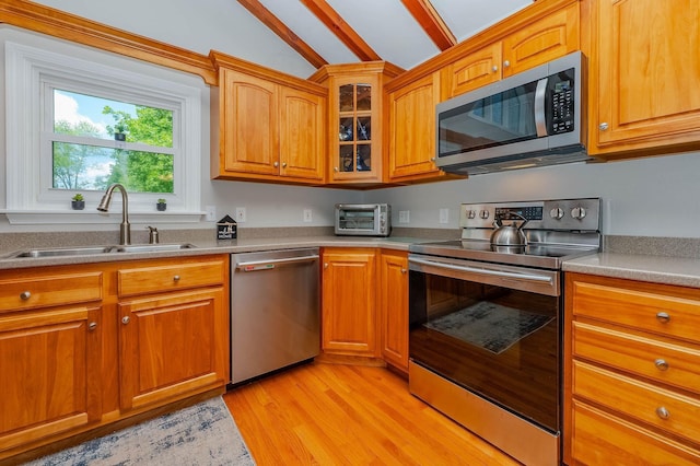 15B Vine St, South Berwick, ME 03908 - kitchen featuring appliances with stainless steel finishes, light wood finished floors, light countertops, and glass insert cabinets