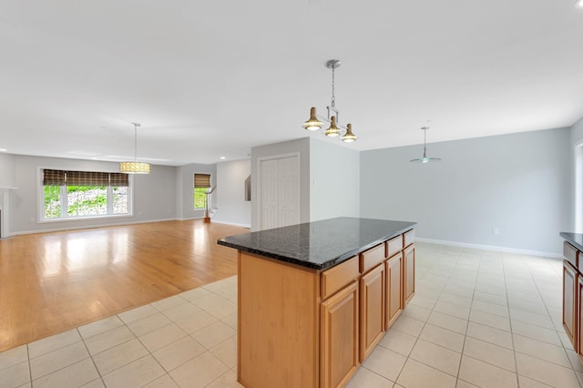 70B Shadowbrook Dr Unit 70B, Hudson, NH 03051 - kitchen featuring open floor plan, light tile patterned floors, a center island, and dark stone countertops