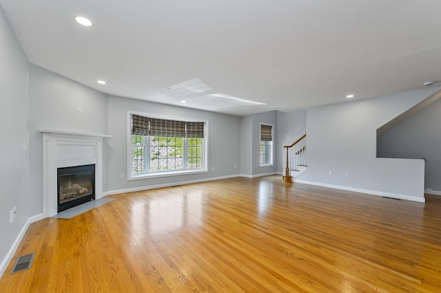 70B Shadowbrook Dr Unit 70B, Hudson, NH 03051 - unfurnished living room featuring stairway, a fireplace with flush hearth, light wood-style flooring, and recessed lighting
