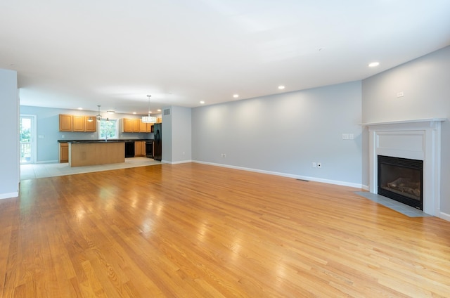 70B Shadowbrook Dr Unit 70B, Hudson, NH 03051 - unfurnished living room with a fireplace with flush hearth, light wood-type flooring, recessed lighting, and a chandelier
