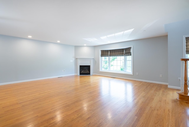 70B Shadowbrook Dr Unit 70B, Hudson, NH 03051 - unfurnished living room with a glass covered fireplace, light wood finished floors, and recessed lighting