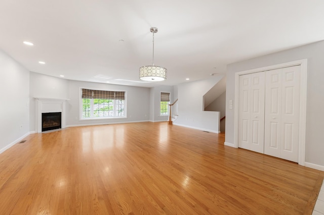 70B Shadowbrook Dr Unit 70B, Hudson, NH 03051 - unfurnished living room featuring light wood finished floors, recessed lighting, a fireplace, and stairway