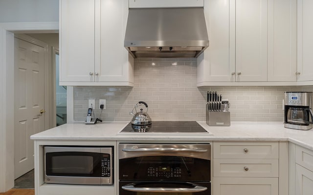 81 Summit Ridge Dr, Keene, NH 03431 - kitchen with stainless steel microwave, wall chimney range hood, wall oven, and white cabinetry