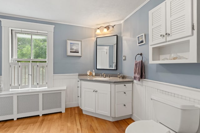 223 Atlantic Ave, North Hampton, NH 03862 - bathroom with radiator heating unit, wainscoting, crown molding, vanity, and wood finished floors