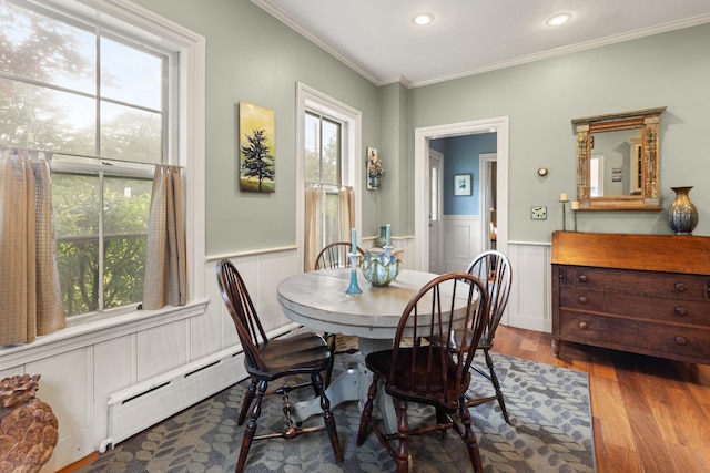 223 Atlantic Ave, North Hampton, NH 03862 - dining space featuring wood finished floors, a baseboard radiator, crown molding, a wainscoted wall, and recessed lighting