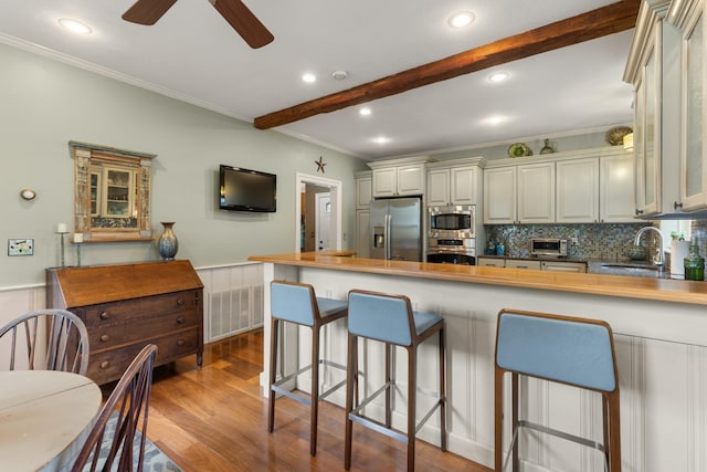 223 Atlantic Ave, North Hampton, NH 03862 - kitchen with appliances with stainless steel finishes, ornamental molding, wood finished floors, a peninsula, and a kitchen breakfast bar