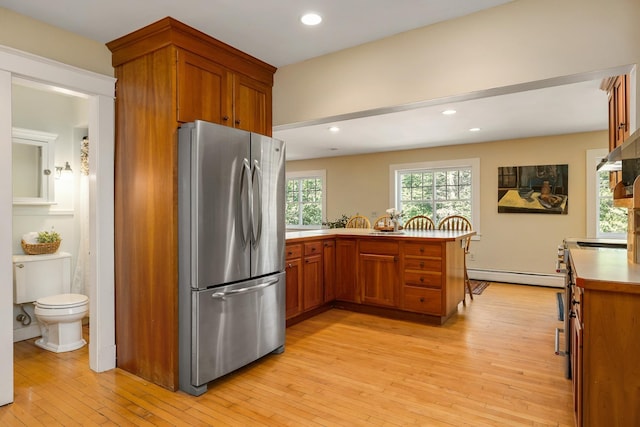 96 Madbury Rd, Durham, NH 03824 - kitchen with freestanding refrigerator, baseboard heating, brown cabinetry, a peninsula, and recessed lighting