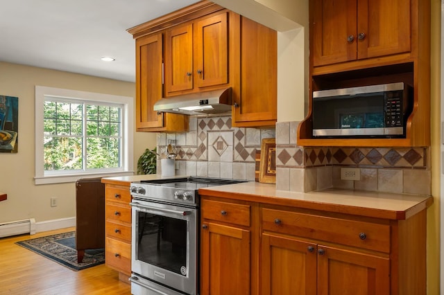 96 Madbury Rd, Durham, NH 03824 - kitchen with appliances with stainless steel finishes, under cabinet range hood, light countertops, brown cabinets, and backsplash