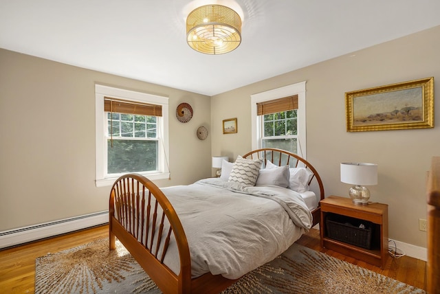 96 Madbury Rd, Durham, NH 03824 - bedroom featuring multiple windows, a baseboard heating unit, and wood finished floors