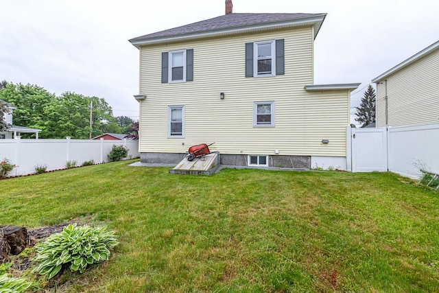 1076 Merrill St, Manchester, NH 03103 - rear view of house featuring a chimney and a fenced backyard