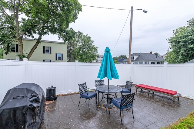 1076 Merrill St, Manchester, NH 03103 - fenced backyard featuring a patio area, grilling area, and outdoor dining area