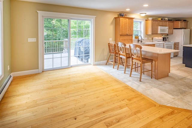 203 Blackwater Rd, Somersworth, NH 03878 - kitchen with white appliances, light countertops, a peninsula, a breakfast bar, and plenty of natural light