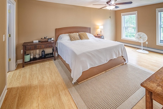 203 Blackwater Rd, Somersworth, NH 03878 - bedroom featuring light wood-type flooring, a baseboard radiator, and a ceiling fan