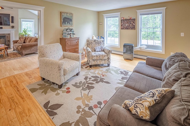 203 Blackwater Rd, Somersworth, NH 03878 - living room featuring wood finished floors, a baseboard radiator, plenty of natural light, and a premium fireplace