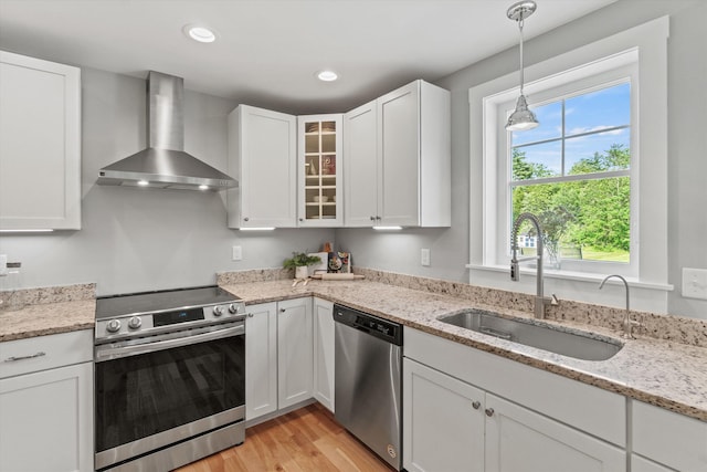 16 Daniels Dr, Lee, NH 03861 - kitchen featuring wall chimney exhaust hood, appliances with stainless steel finishes, white cabinetry, and recessed lighting