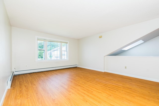 703 Springbrook Cir, Portsmouth, NH 03801 - spare room featuring light wood-style floors, a skylight, and a baseboard radiator