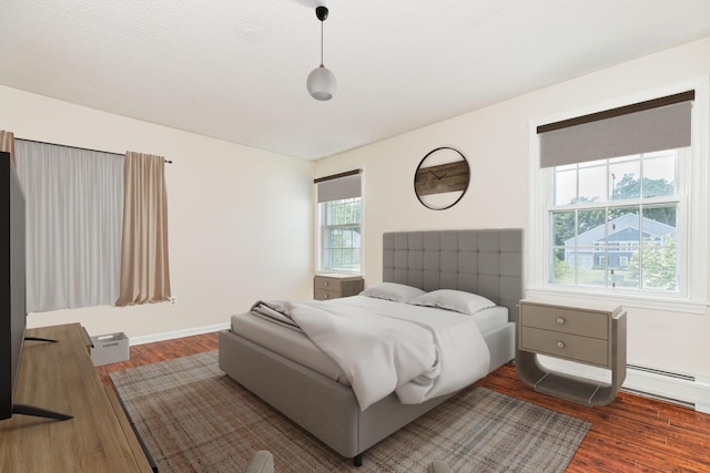 703 Springbrook Cir, Portsmouth, NH 03801 - bedroom featuring wood finished floors and a baseboard heating unit