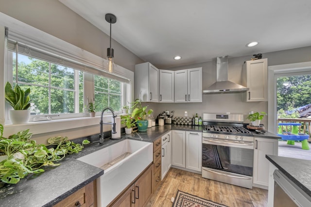 86 Chestnut St, Claremont, NH 03743 - kitchen featuring wall chimney exhaust hood, stainless steel appliances, dark countertops, healthy amount of natural light, and recessed lighting