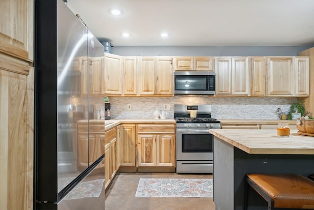 153 May St, Canaan, NH 03741 - kitchen with stainless steel appliances, light brown cabinets, butcher block countertops, decorative backsplash, and a kitchen bar