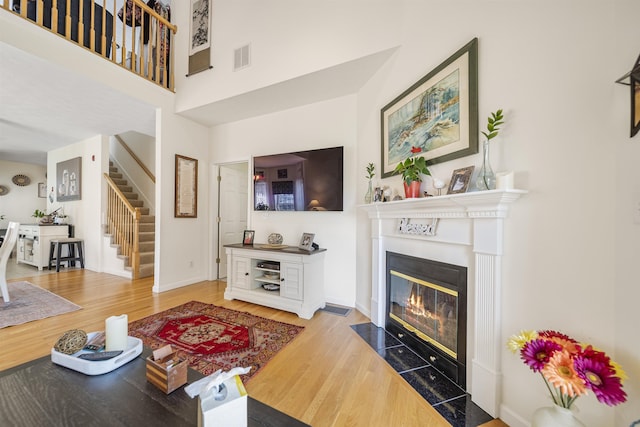 34 Mammoth Rd Unit 1, Hooksett, NH 03106 - living room with stairway, wood finished floors, a fireplace with flush hearth, and a towering ceiling
