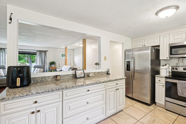 20 Meadow Ln, Atkinson, NH 03811 - kitchen with stainless steel appliances, light tile patterned floors, light stone counters, white cabinets, and open floor plan