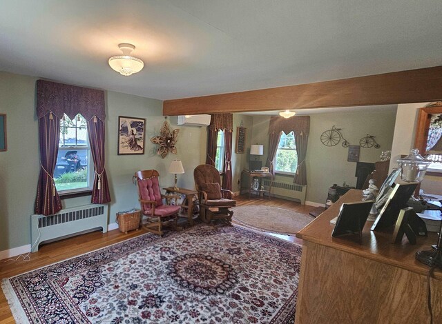 18 Cross St, Allenstown, NH 03275 - living area featuring radiator heating unit, a wall mounted AC, and wood finished floors