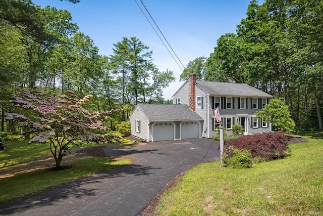 7 Dearborn Ln, Bedford, NH 03110 - colonial house with a chimney, an attached garage, asphalt driveway, a front yard, and roof with shingles