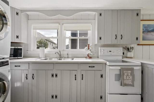 8 Red Coat Ln, Hampton, NH 03842 - kitchen featuring estacked washer and dryer, electric stove, stainless steel microwave, and light countertops