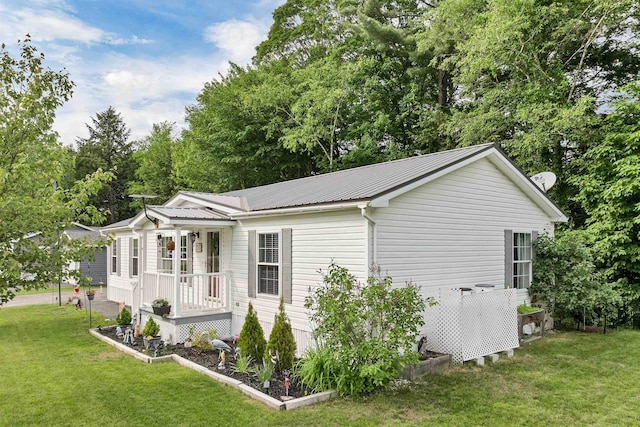 638 Benton Dr, Laconia, NH 03246 - view of property exterior with a yard, a metal roof, and a porch