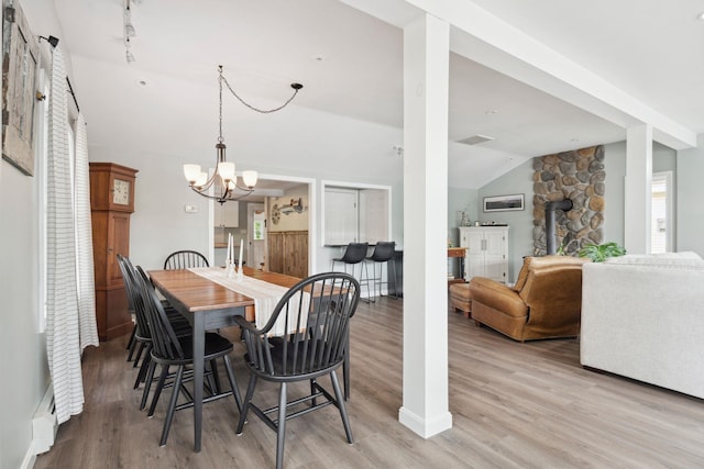 161 Micah Ter, Milton, NH 03851 - dining room with vaulted ceiling, light wood-type flooring, a wood stove, and a chandelier
