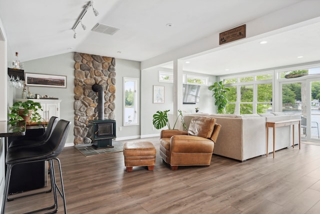 161 Micah Ter, Milton, NH 03851 - living room featuring rail lighting, vaulted ceiling, wood finished floors, and a wood stove