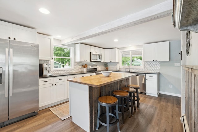 161 Micah Ter, Milton, NH 03851 - kitchen with stainless steel appliances, wood counters, dark wood-style floors, a breakfast bar area, and white cabinets