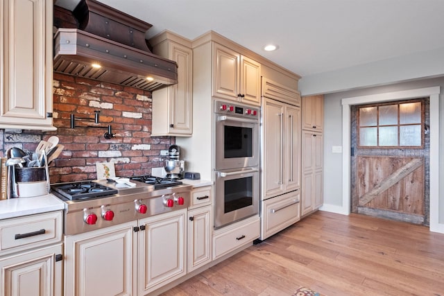 15 Glade Cir, Campton, NH 03223 - kitchen with stainless steel appliances, custom range hood, cream cabinets, light countertops, and recessed lighting