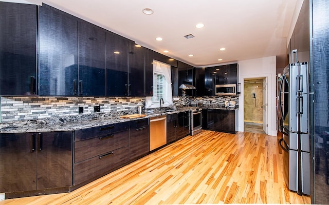 53 Lollypop Ln, Danville, NH 03819 - kitchen with appliances with stainless steel finishes, modern cabinets, light wood-style flooring, tasteful backsplash, and recessed lighting