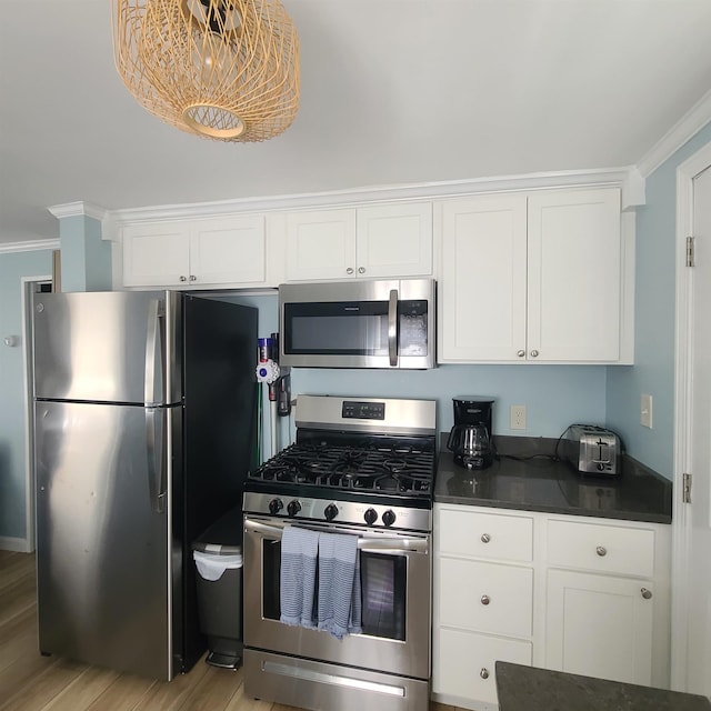 14 Johnson Ave Unit A, Hampton, NH 03842 - kitchen with appliances with stainless steel finishes, dark countertops, crown molding, white cabinetry, and light wood-type flooring