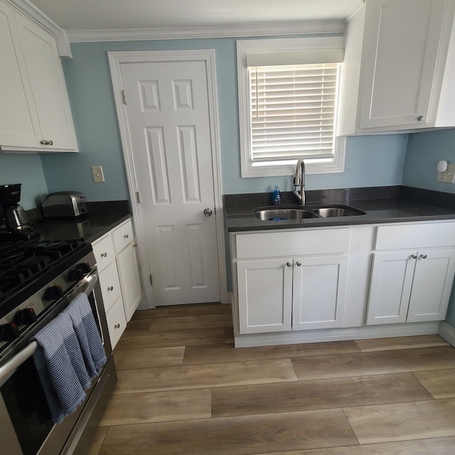 14 Johnson Ave Unit A, Hampton, NH 03842 - kitchen with gas stove, dark countertops, light wood-style flooring, white cabinetry, and ornamental molding