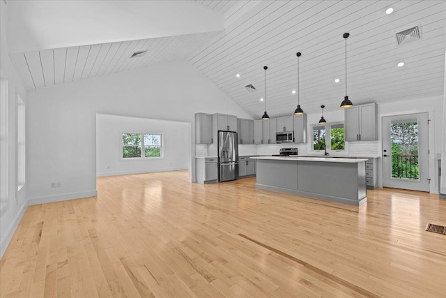 29 Taft St, Essex Junction, VT 05452 - kitchen with gray cabinets, appliances with stainless steel finishes, light countertops, high vaulted ceiling, and a kitchen island