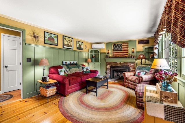 9 Jade Rd, Merrimack, NH 03054 - living room with hardwood / wood-style floors, a wall mounted AC, a brick fireplace, a decorative wall, and ornamental molding