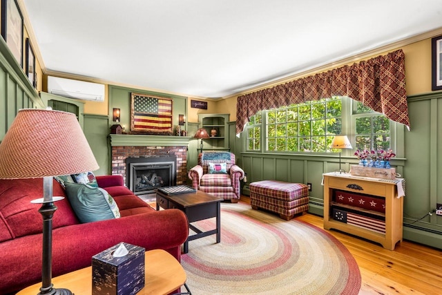 9 Jade Rd, Merrimack, NH 03054 - living room with a wall unit AC, a decorative wall, wood finished floors, a brick fireplace, and a baseboard heating unit