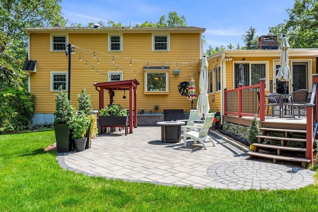 9 Jade Rd, Merrimack, NH 03054 - back of property featuring a deck, a patio area, a fire pit, a lawn, and a chimney