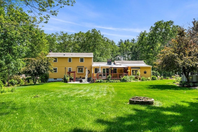 9 Jade Rd, Merrimack, NH 03054 - rear view of house with an outdoor fire pit, a wooden deck, and a yard