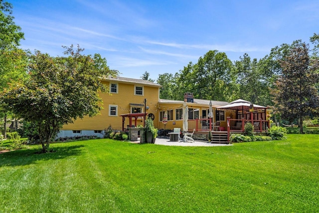 9 Jade Rd, Merrimack, NH 03054 - back of property with a patio area, a lawn, a wooden deck, a chimney, and a gazebo
