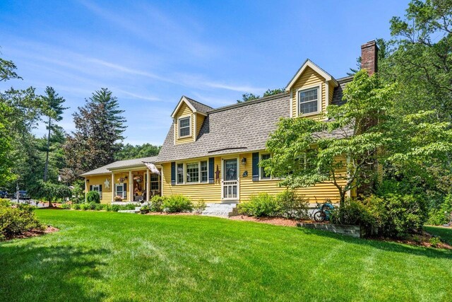 9 Jade Rd, Merrimack, NH 03054 - view of front of house with a front lawn, a chimney, roof with shingles, and a porch