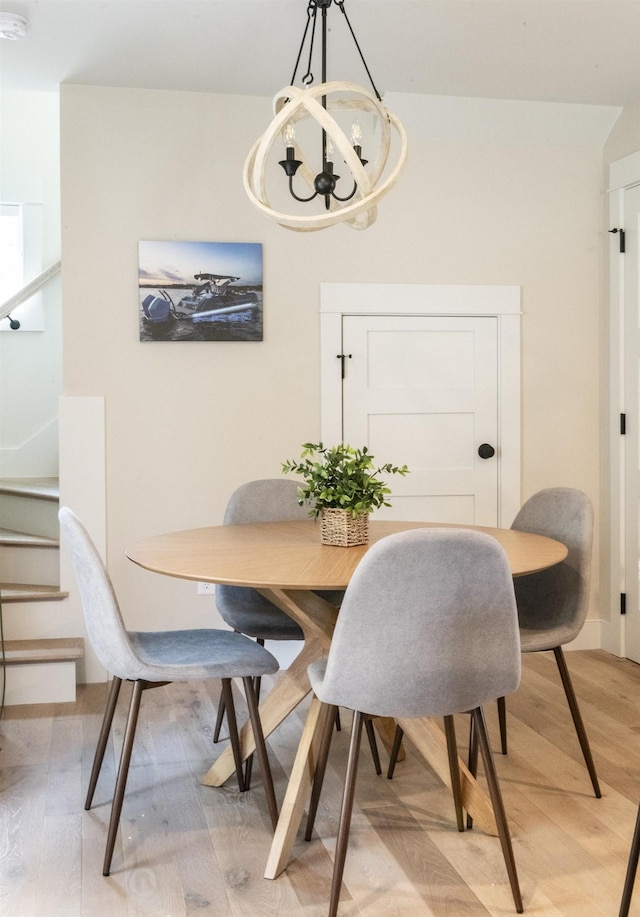 109 Weirs Blvd Unit 9, Laconia, NH 03246 - dining room featuring light wood finished floors, a chandelier, and stairway