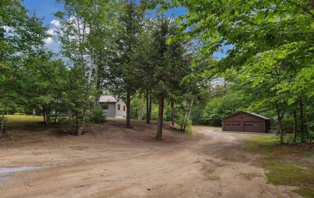 13 Seyah Rd, Shelburne, NH 03581 - view of yard featuring an outdoor structure, a detached garage, and dirt driveway